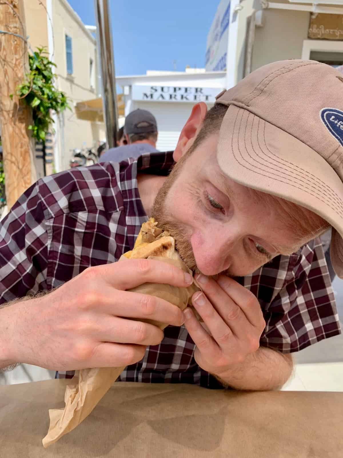 Man eating a Greek Gyro Sandwich